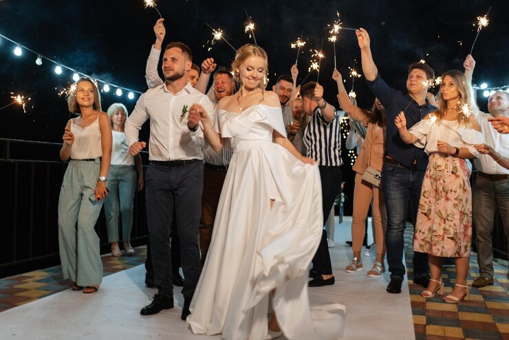 Foto bengalas en la boda de los recién casados en manos de alegres invitados.