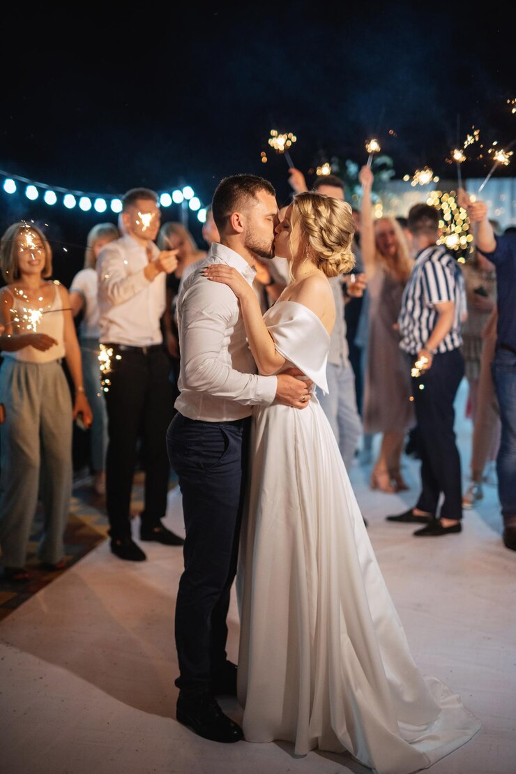 Foto bengalas en la boda de los recién casados en manos de alegres invitados.
