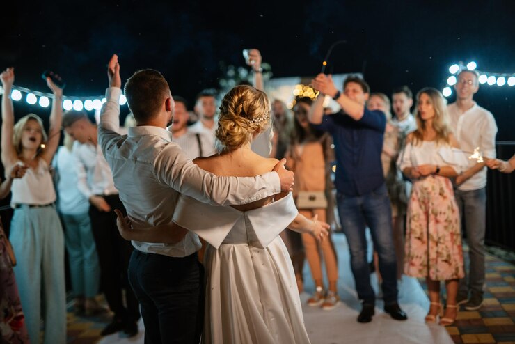 Foto bengalas en la boda de los recién casados en manos de alegres invitados.