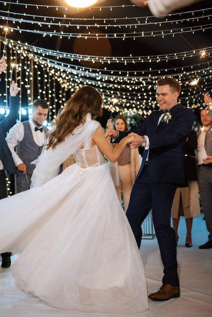 Bengalas en la boda de los recién casados en manos de alegres invitados.