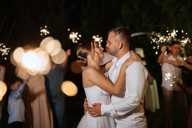 Bengalas en la boda de los recién casados en manos de alegres invitados.