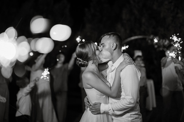 Bengalas en la boda de los recién casados en manos de alegres invitados.