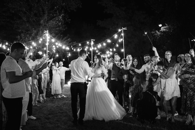 Bengalas en la boda de los recién casados en manos de alegres invitados.