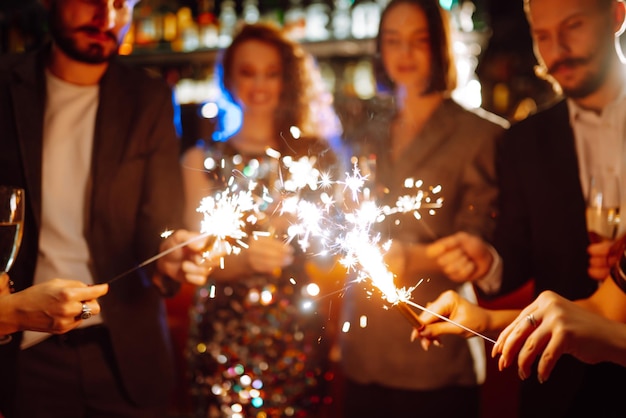 Bengalas brillantes en las manos Jugar fuegos artificiales para celebrar las vacaciones de invierno Año Nuevo Mágico