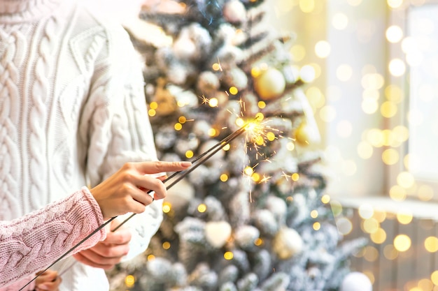 Bengalas de Navidad en manos de un hombre y una mujer, vacaciones, enfoque selectivo.