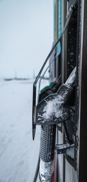 Benzin- oder Dieselbetankungsschlauch und -pistole, umgeben von Schneemorgensonne in Island