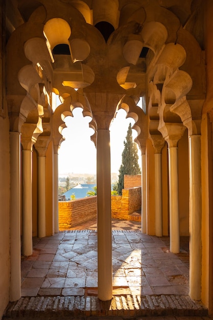 Beobachten des Sonnenuntergangs von den arabischen Türen eines Innenhofs der Alcazaba in der Stadt Malaga, Andalusien. Spanien. Mittelalterliche Festung im arabischen Stil