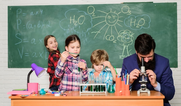 Beobachten Sie die Reaktion Wissenschaft ist immer die Lösung Schulchemie-Experiment Kindern die Chemie erklären Faszinierende Chemiestunde Mann bärtiger Lehrer und Schüler mit Reagenzgläsern im Klassenzimmer