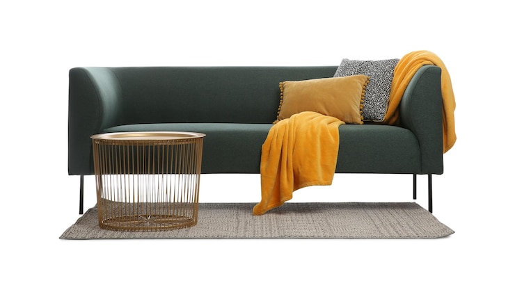 Foto bequeme grüne couch mit kissen, decke und tisch auf weißem hintergrund möbel für das wohnzimmer