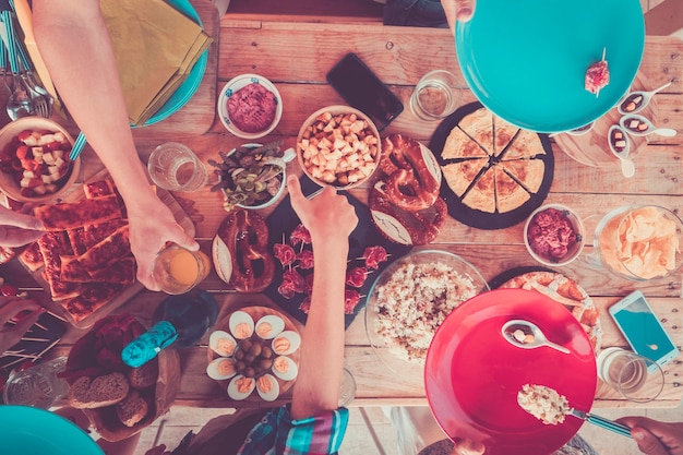 Über Ansicht von Freunden, die zusammen Essen vom Tisch in rosa Stimmungsfilterfarben essen Konzept von Menschen, die während der Freizeitbeschäftigung zum Mittagessen oder Brunch in der Gruppe feiern und Spaß haben