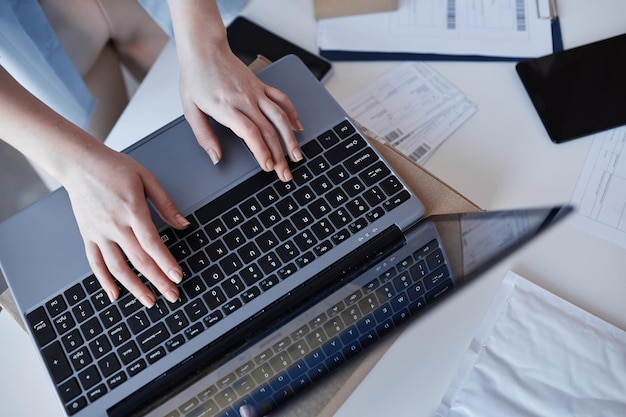 Über dem Winkel der Hände einer jungen Frau über der Laptoptastatur