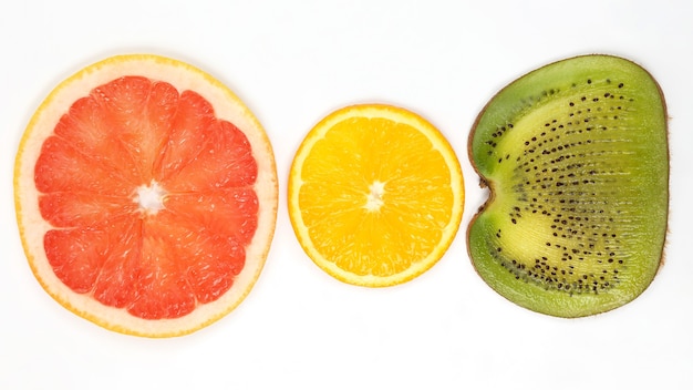 Über geschnittene Kiwi, Orange und Grapefruit auf weißem Hintergrund. Nützliche Vitaminnahrung aus Obst