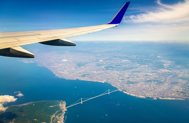 Über Japan fliegen: Blick auf die Akashi Kaikyo Brücke durch ein Flugzeugfenster