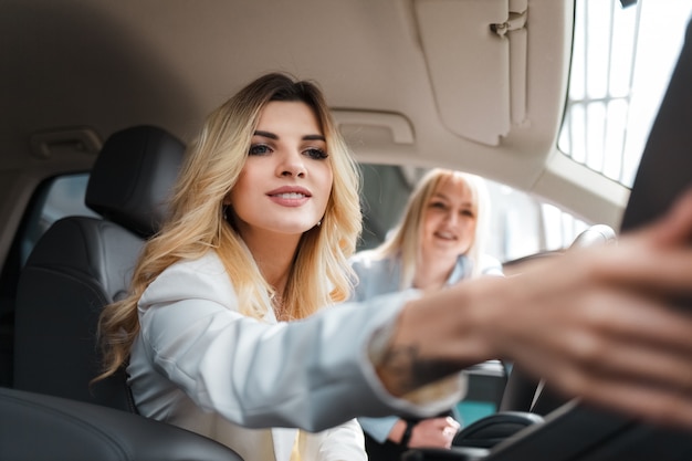 Berater, der einem Kunden den Innenraum des Autos zeigt