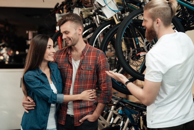 Berater hilft jungen Paaren bei der Fahrradwahl.