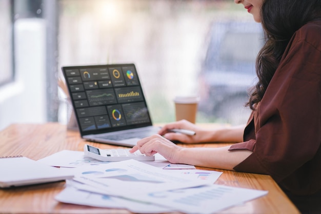 Beraterin für Finanz- und Geschäftsanalyse, Frau, die Daten analysiert, Diagramme, Grafiken und ein Dashboard auf dem Laptop-Bildschirm, Konzept der Datenanalyse