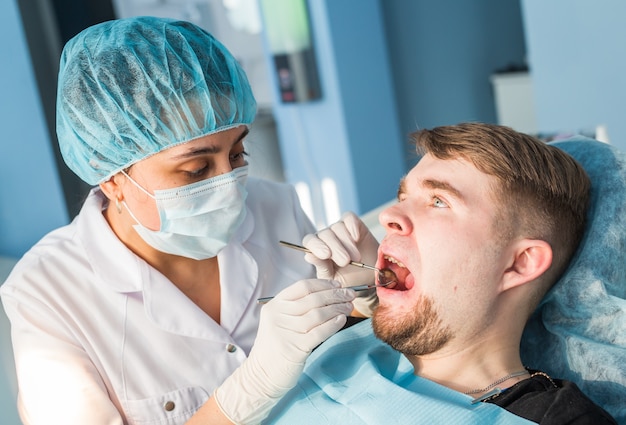 Überblick über die Kariesprävention. Mann am Zahnarztstuhl während eines zahnärztlichen Eingriffs.