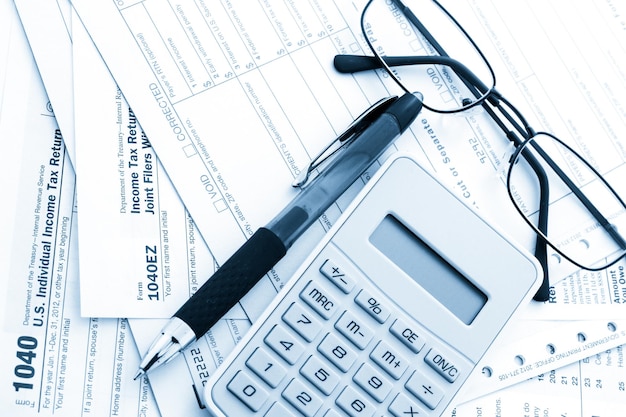 Berechnung von Zahlen für die Einkommensteuererklärung mit Stift und calculato