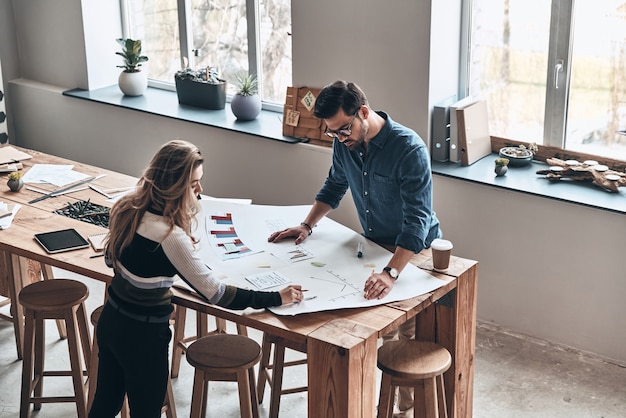 Bereit, hart zu arbeiten. Draufsicht auf junge Kollegen in Smart Casual Wear mit Blaupause