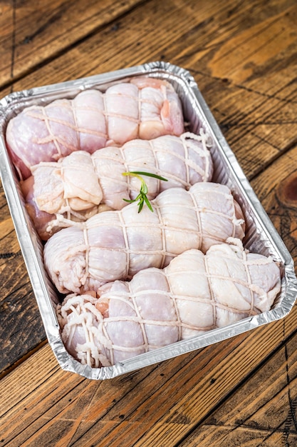 Bereit zum Kochen rohe Hähnchenbrötchen gefüllt mit Käse und Schinken in einer Auflaufform Holzhintergrund Ansicht von oben