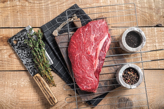 Bereit zum Kochen von rohem Rinderfiletsteak auf einem Grill oder Rumpsteak Holzhintergrund Ansicht von oben