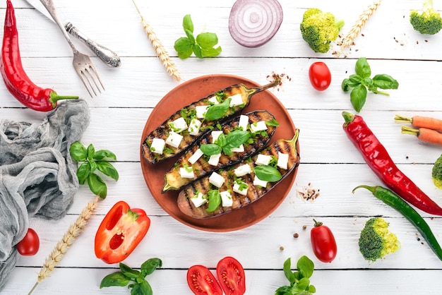 Berenjena a la parrilla con queso feta y albahaca Comida saludable En una mesa de madera blanca Vista superior Espacio libre para texto