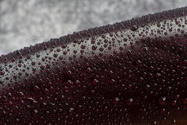 Foto berenjena bajo una tabla de madera rociada con agua para prepararla para la ensalada