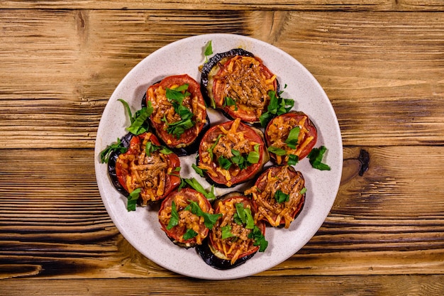 Berenjenas al horno con tomate y queso en un plato de cerámica. Vista superior