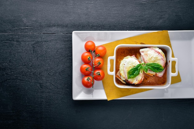 Berenjenas y calabacines al horno con salsa de queso mozzarella Sobre un fondo de madera Vista superior Espacio libre para texto