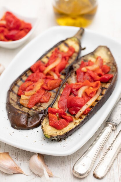 Berenjenas a la plancha con pimiento rojo en plato blanco