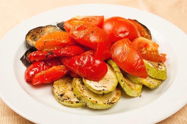 Berenjenas a la plancha y tomates en el plato en restaurante.