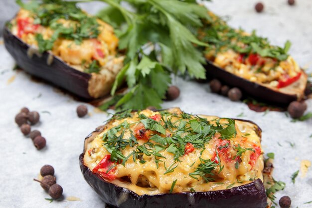 Berenjenas rellenas al horno. Berenjenas al horno sobre pergamino con queso, tomate y hierbas