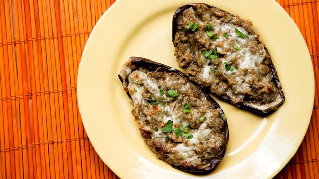 Berenjenas rellenas de carne picada y cocidas al horno con queso.