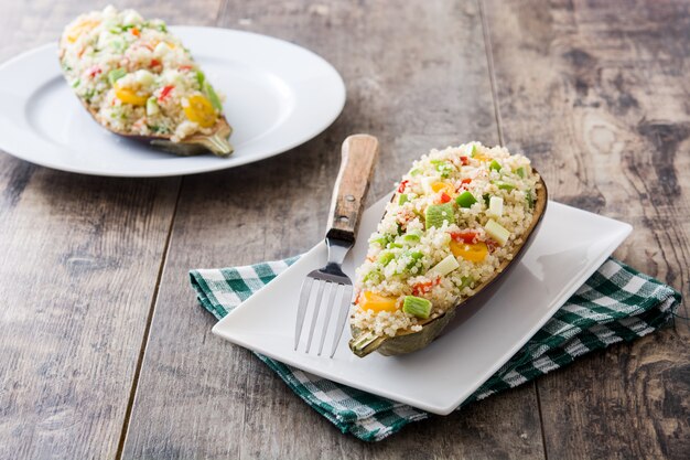 Berenjenas rellenas con quinua y verduras en la mesa de madera