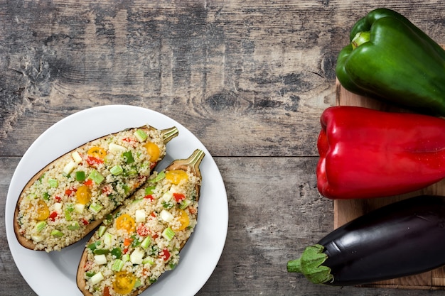 Berenjenas rellenas con quinua y verduras sobre fondo de madera