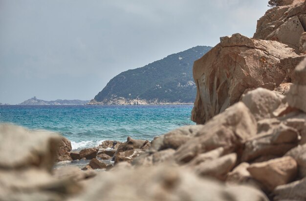 Berg am Meer im Süden Sardiniens, der im Sommer von einer Klippe mit Meereswellen gefiltert wird