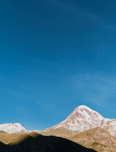 Berg kazbek in den strahlen der morgensonne vertikalen rahmen frühherbst in den bergen hoher kaukasus georgien