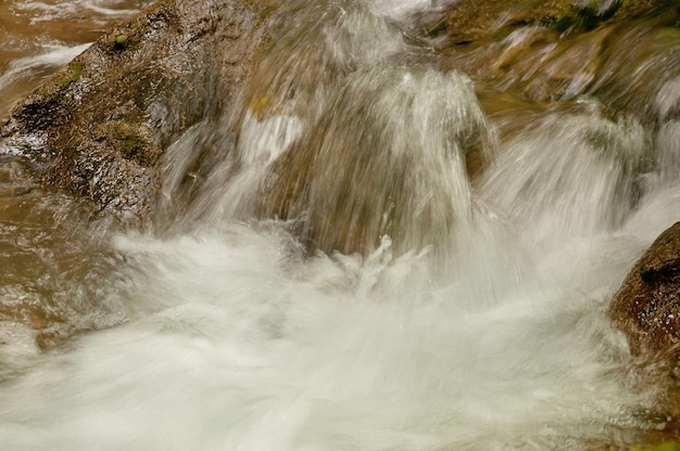 Berg schnell fließender Fluss Wasser in den Felsen mit Moos