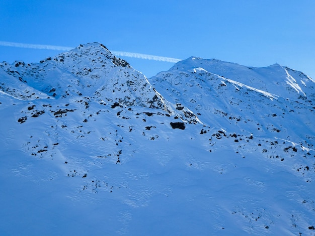 Foto berge mit dunklen felsen, die durch den schnee spiegeln