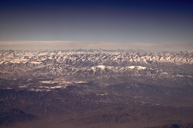 Foto berge mit schneebedeckten gipfeln am blauen himmel luftansicht planet erde natürliche landschaft reisen um die welt umweltschutz und ökologie der tag der erde ist der weltgeburtstag