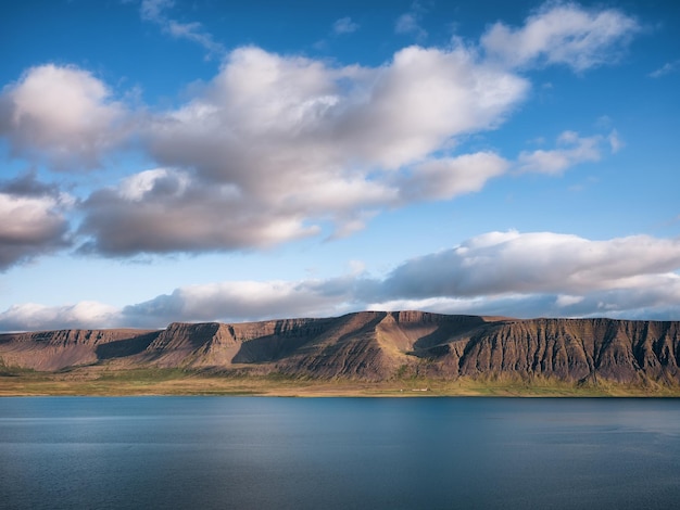 Berge und Meer in Island Hohe Felsen und Wolken zur Tageszeit Natürliche Landschaft im Sommer Island-Bild