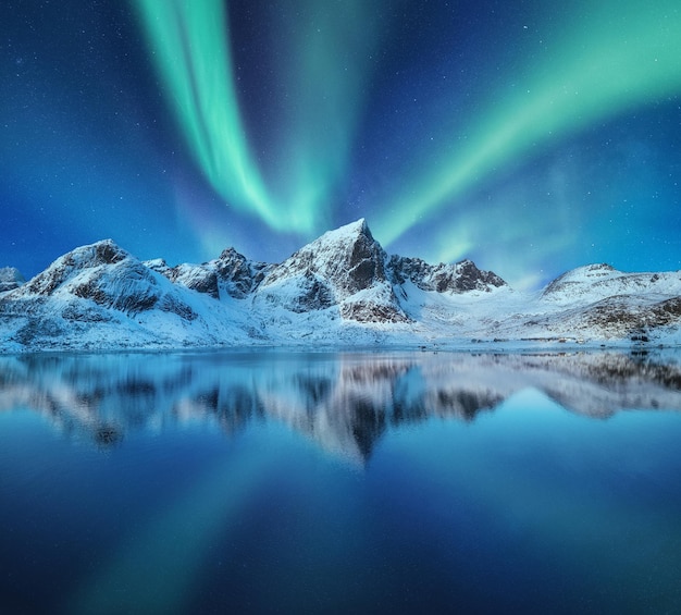 Berge und Nordlichter am Himmel Reflexionen des Nachthimmels und der Berge auf dem Wasser Winterlandschaft in Norwegen