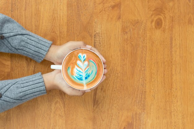 Übergeben Sie das Halten der Schale heißen Lattekunstkaffees im Café.