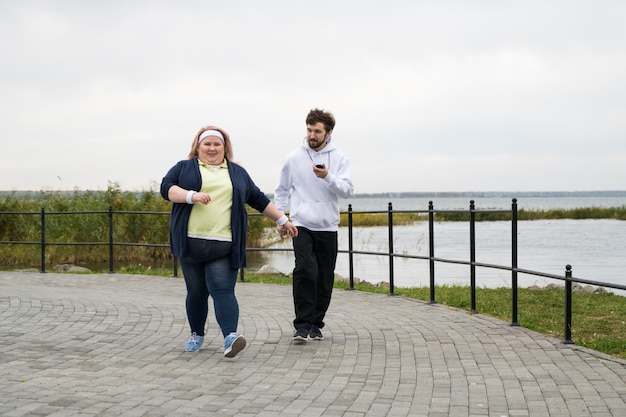 Übergewichtige Frau, die draußen joggt