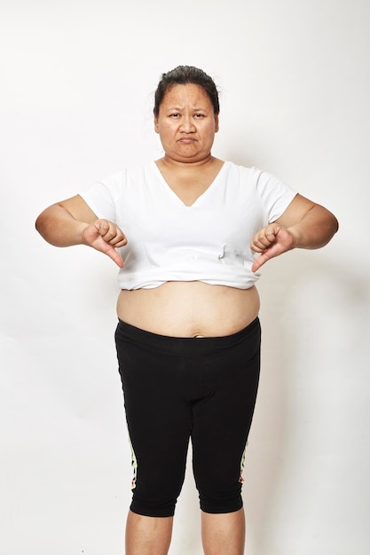 Übergewichtige Frau steht vor weißem Hintergrund