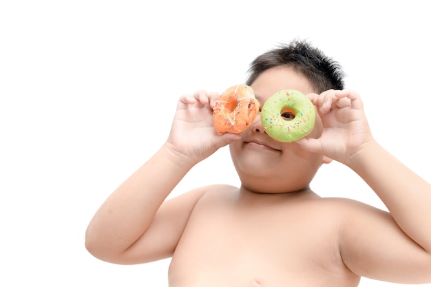 Übergewichtiger fetter Junge isst den lokalisierten Donut