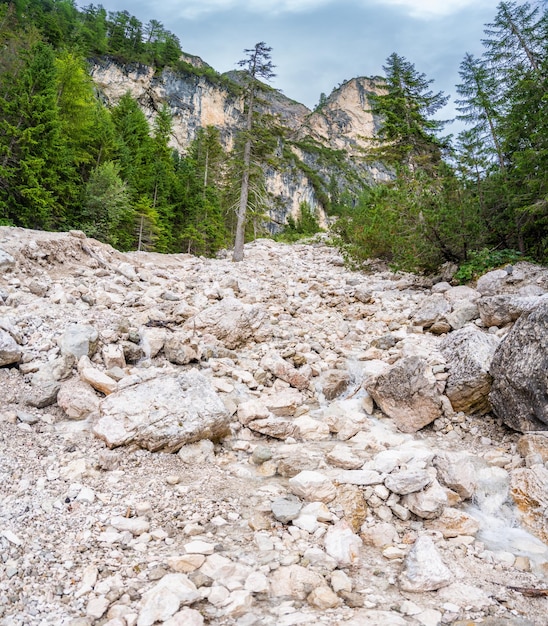 Bergfluss, der in den Braies-See mündet, umgeben von Kiefernwäldern und den felsigen Gebirgen des