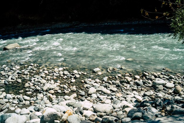 Bergfluss, der in der Nähe der Steinküste fließt Saubere Wasserstraße fließt bei sonnigem Wetter über Steine