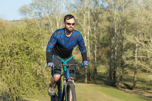 Berggipfel erobern mit Radler in Shorts und Jersey auf einem modernen Carbon-Hardtail-Bike mit a