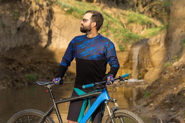 Berggipfel erobern mit Radler in Shorts und Jersey auf einem modernen Carbon-Hardtail-Bike mit Luftfedergabel